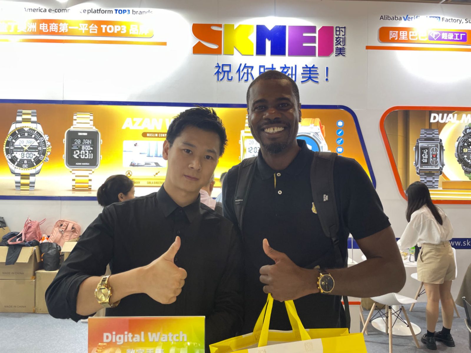 SKMEI sales representative with an overseas buyer giving thumbs up at the 2023 Hong Kong booth