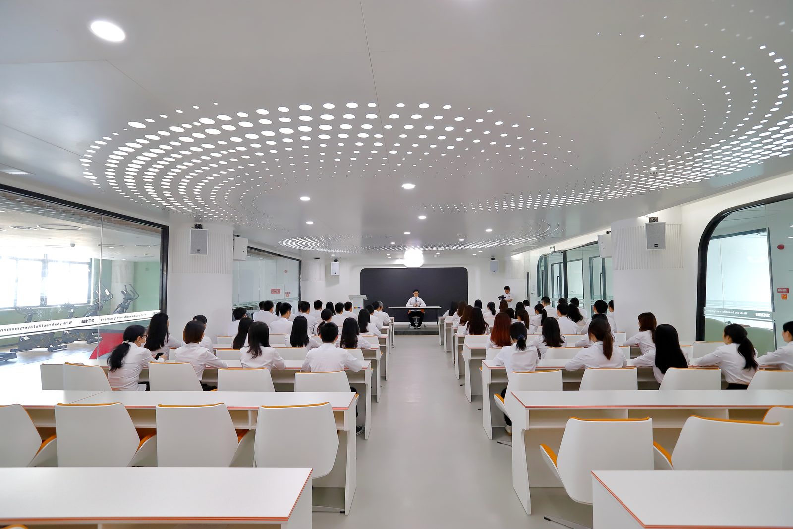 Training hall with rows of desks and a presentation screen